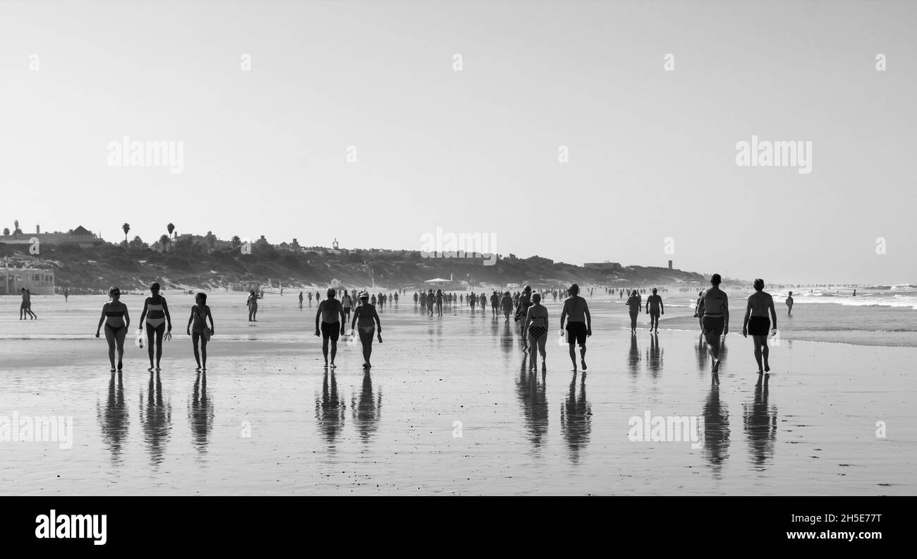 Spaziergänger am frühen Morgen am Strand von La Barrosa, Sancti Petri, Chiclana de la Frontera, Cadaz, Andalusien, Spanien. Stockfoto