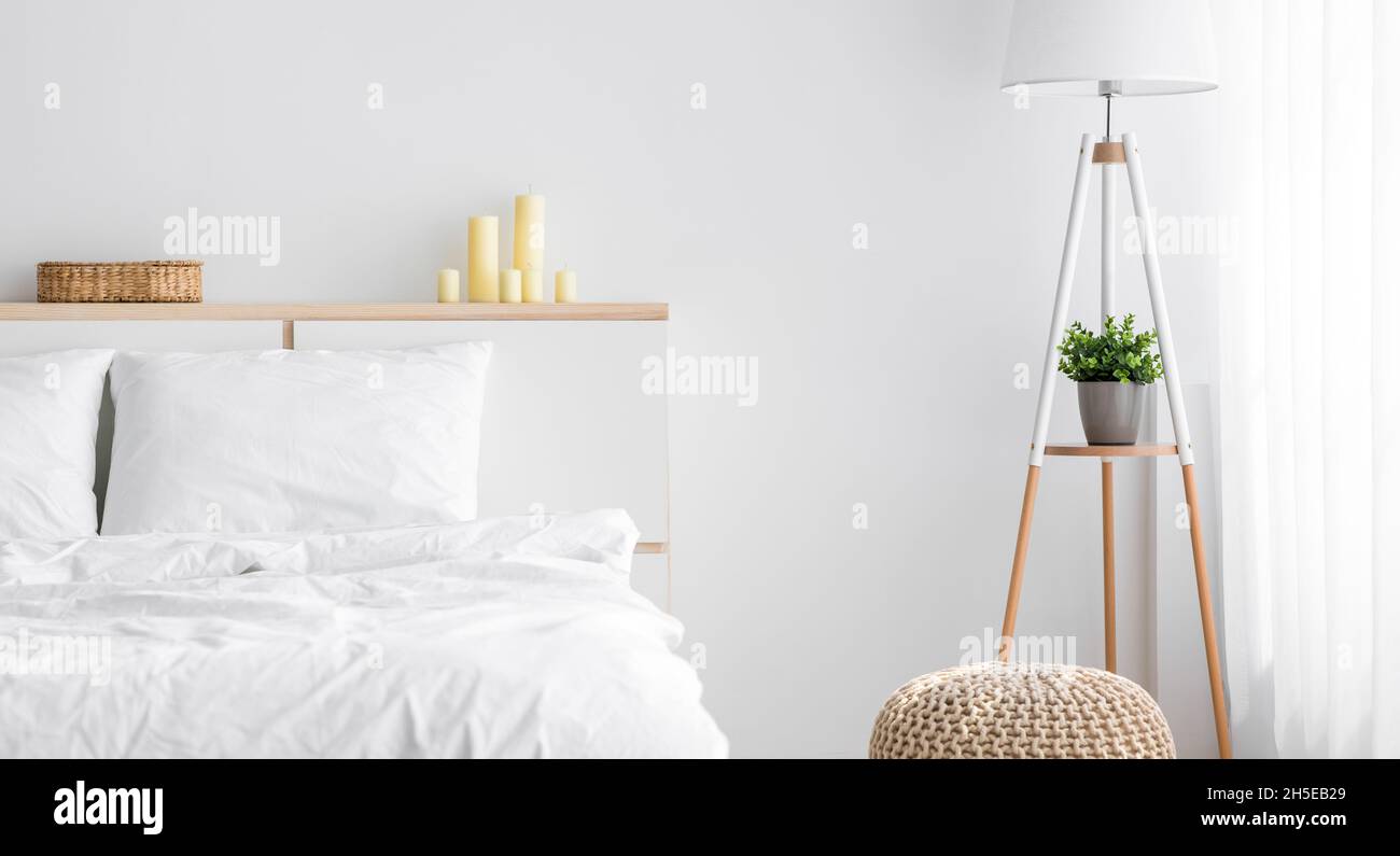 Großes Bett mit bequemer Bettwäsche, Lampe mit Pflanze, Möbel mit Zubehör, Fenster mit Vorhang Stockfoto