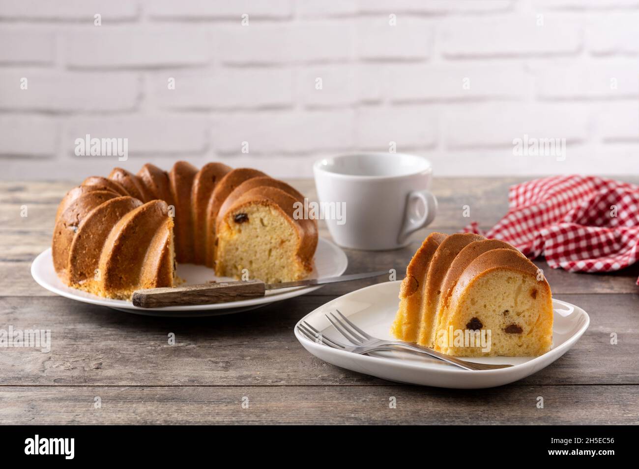Traditionelles gebundenes Kuchenstück mit Rosinen auf Holztisch Stockfoto