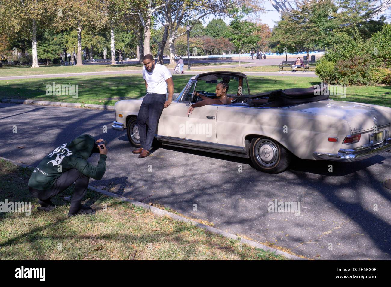 Ein Fotoshooting mit einem Model, Musiker, Fotograf und Mercedes Benz Cabrio in einem Park in Queens, New York City. Stockfoto
