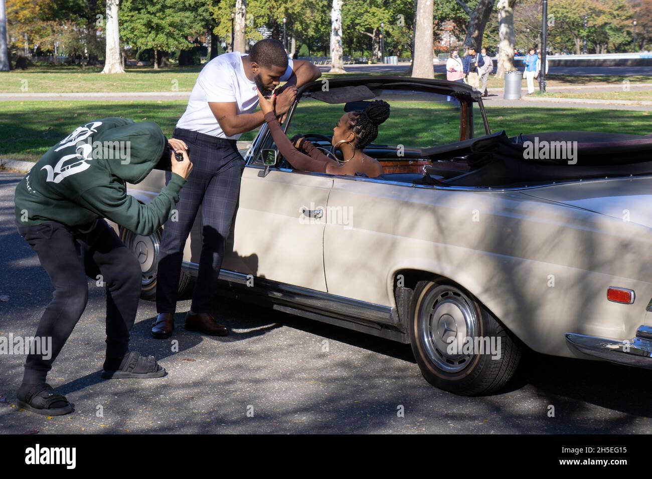 Ein Fotoshooting mit einem Model, Musiker, Fotograf und Mercedes Benz Cabrio in einem Park in Queens, New York City. Stockfoto