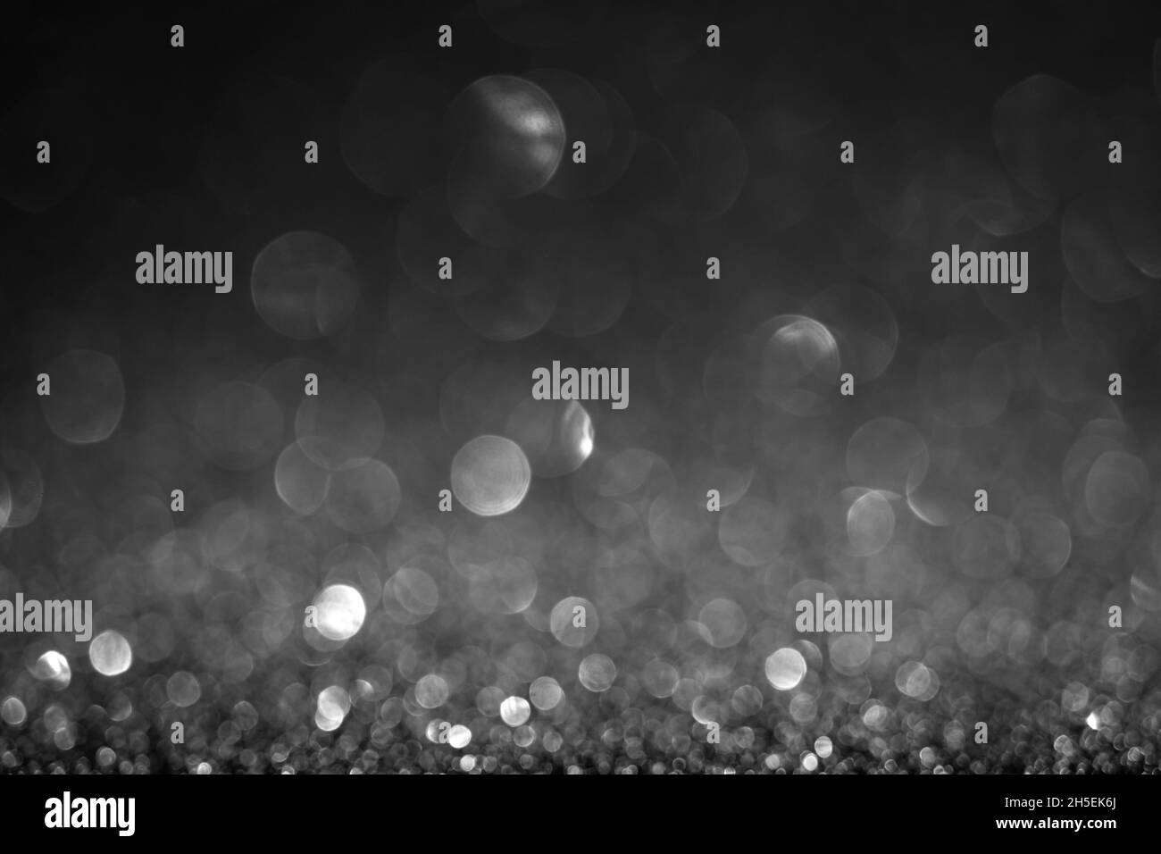 Schwarzer Bokeh-Hintergrund. Vintage Glitzer Lichter, leuchtende weihnachtseffekte Hintergrund Stockfoto