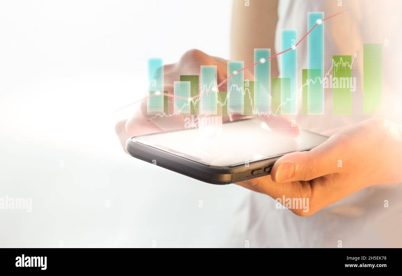 Wachstumsdiagramm positive Indikatoren in der Wirtschaft, Smartphone in der Wirtschaft, Technologie und das Konzept der Menschen - eine Nahaufnahme einer weiblichen Hand halten und s Stockfoto