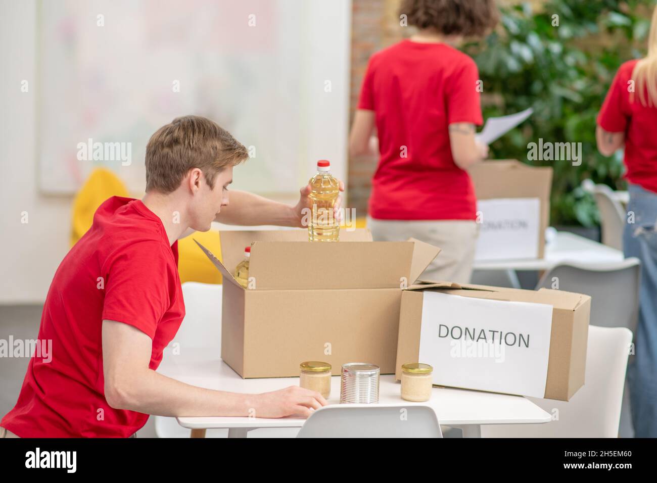 Eine Gruppe junger Freiwilliger bei der Arbeit an einem Verteilungspunkt Stockfoto