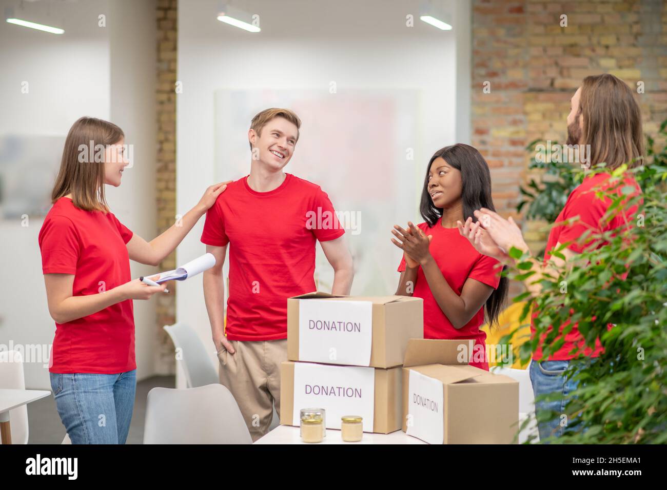 Eine Gruppe junger Freiwilliger bei der Arbeit an einem Verteilungspunkt Stockfoto