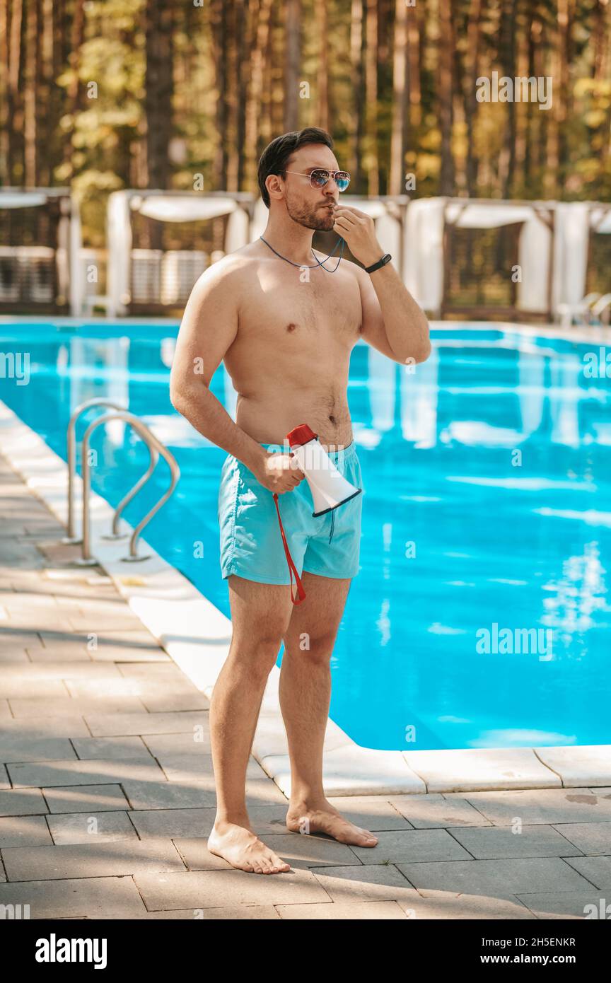 Ein männlicher Rettungsschwimmer warnt die Besucher vor einer Notsituation Stockfoto