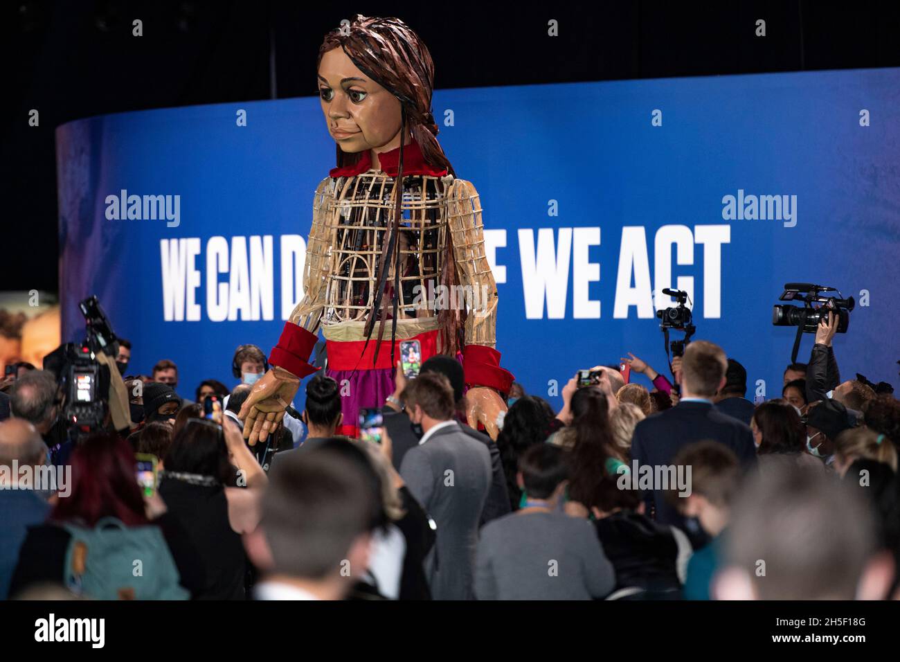 Glasgow, Schottland, Großbritannien. November 2021. IM BILD: Die riesige Marionette ‘Little Amal' steht auf der COP26 Klimakonferenz in der OVO Arena mit einem Transparent darunter, auf dem die Worte „1.8 MILLIONEN MENSCHEN SAGEN: CSAVE OUT FUTURE NOW“ enthüllt werden. Quelle: Colin Fisher/Alamy Live News Stockfoto