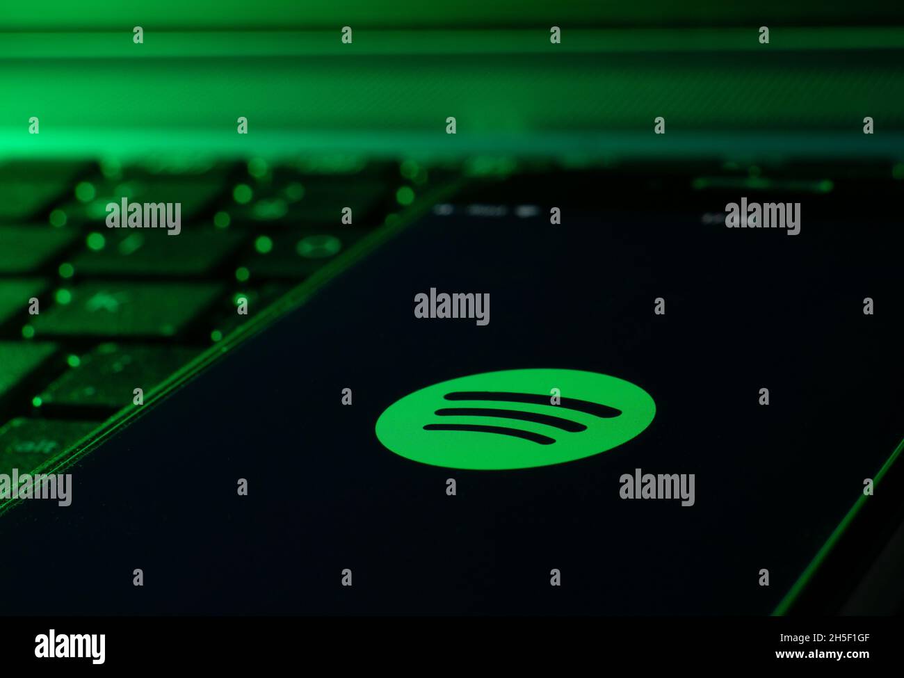 Smartphone auf einer Computertastatur mit der Spotify Musik-App Stockfoto