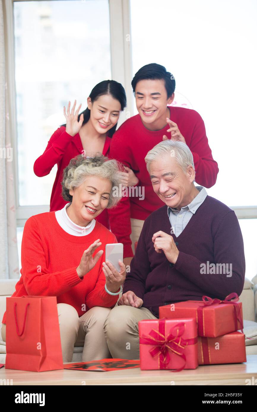 Glückliche Familien, die im neuen Jahr Videoanruf auf einem Mobiltelefon tätigen Stockfoto