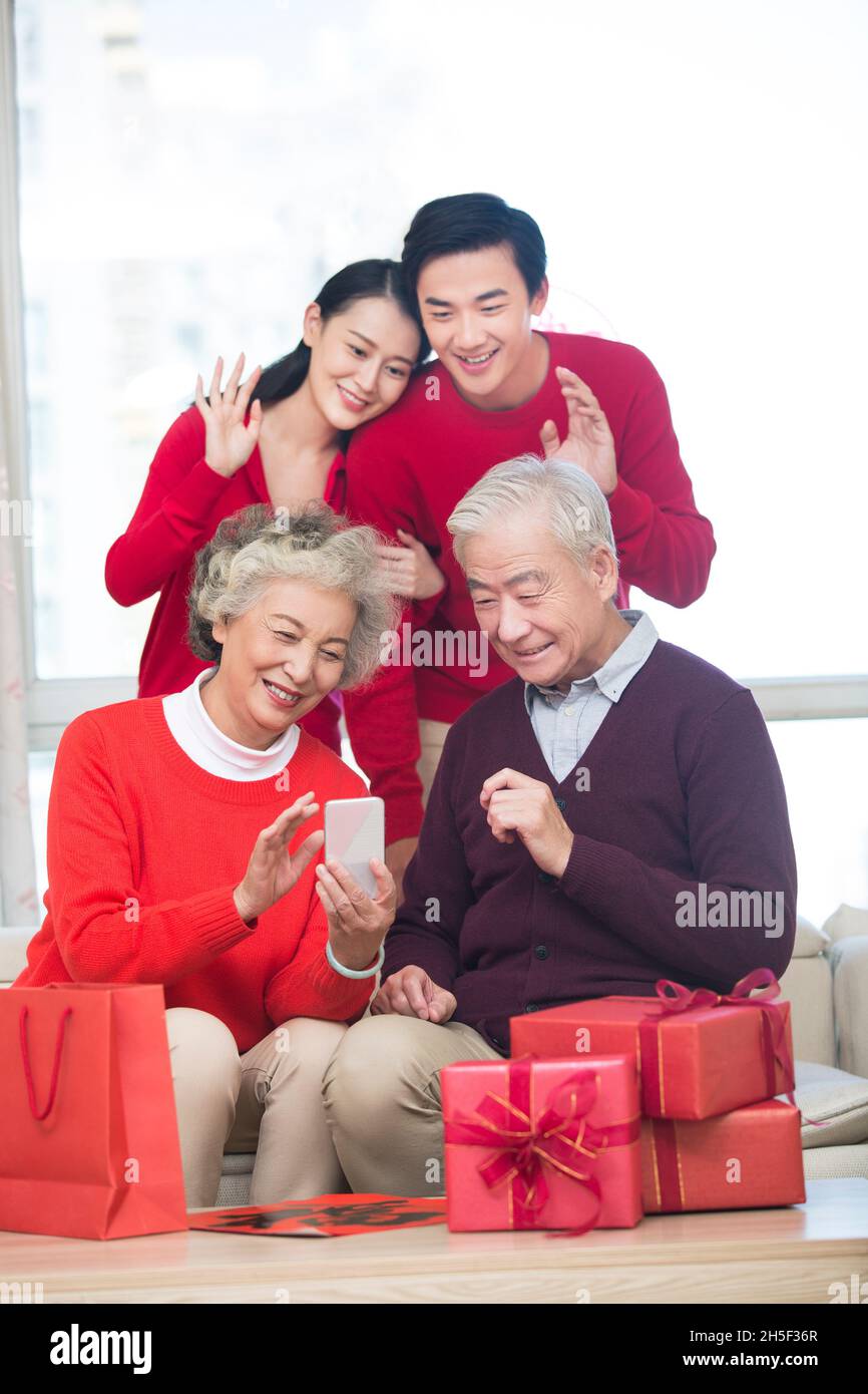 Glückliche Familien, die im neuen Jahr Videoanruf auf einem Mobiltelefon tätigen Stockfoto