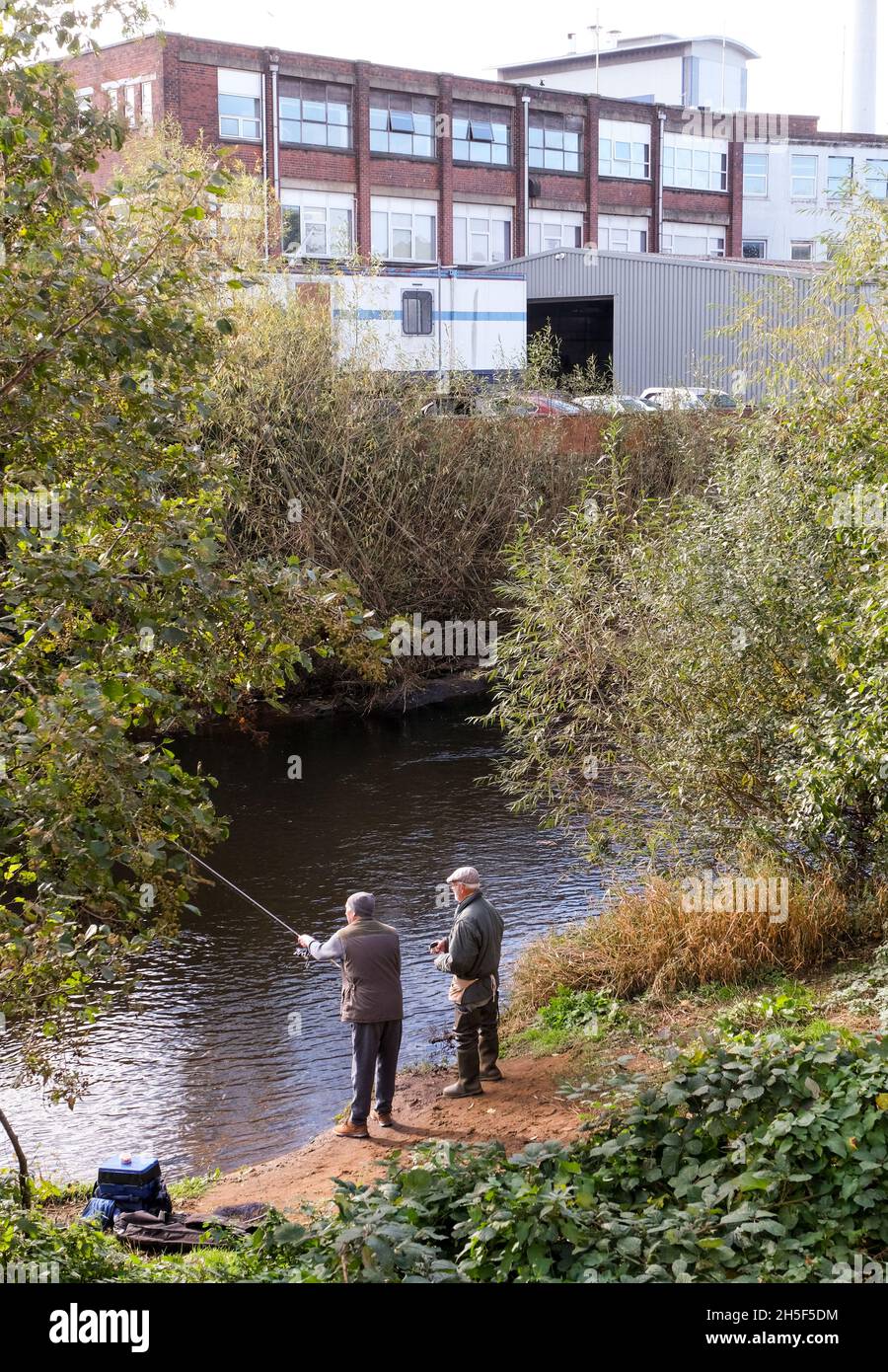 Zwei Herren, die im Fluss Don im Zentrum von Sheffield mit Industriegebäuden fischen. Stockfoto Zwei Herren, die im Fluss Don im Zentrum von Sheffield mit Industriegebäuden fischen. Stockfoto