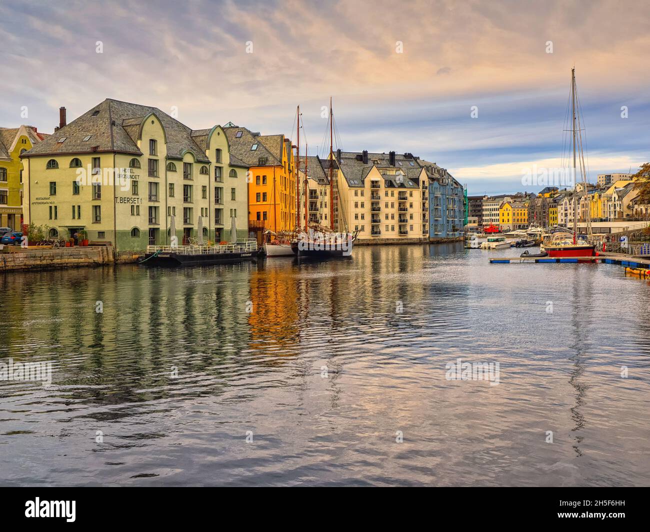 Die schönen farbigen Gebäude entlang des Brosundet-Kanals. Der Kanal verbindet die südliche Hafenfront mit dem inneren Teil der Ålesund-Straße. Stockfoto
