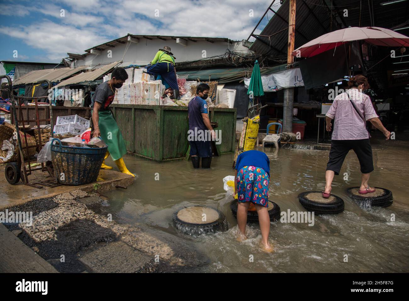 Samut Prakarn, Thailand. November 2021. Während einer Sturzflut auf dem Pak Nam Frischemarkt in Samut Prakan waten Menschen durch eine überflutete Straße.Blitzfluten ereigneten sich in vielen niedrig gelegenen Gebieten neben dem Chao Phraya Fluss in Bangkok und nahe gelegenen Provinzen wie Samut Prakan in Nonthaburi aufgrund starker Regenfälle. Kredit: SOPA Images Limited/Alamy Live Nachrichten Stockfoto