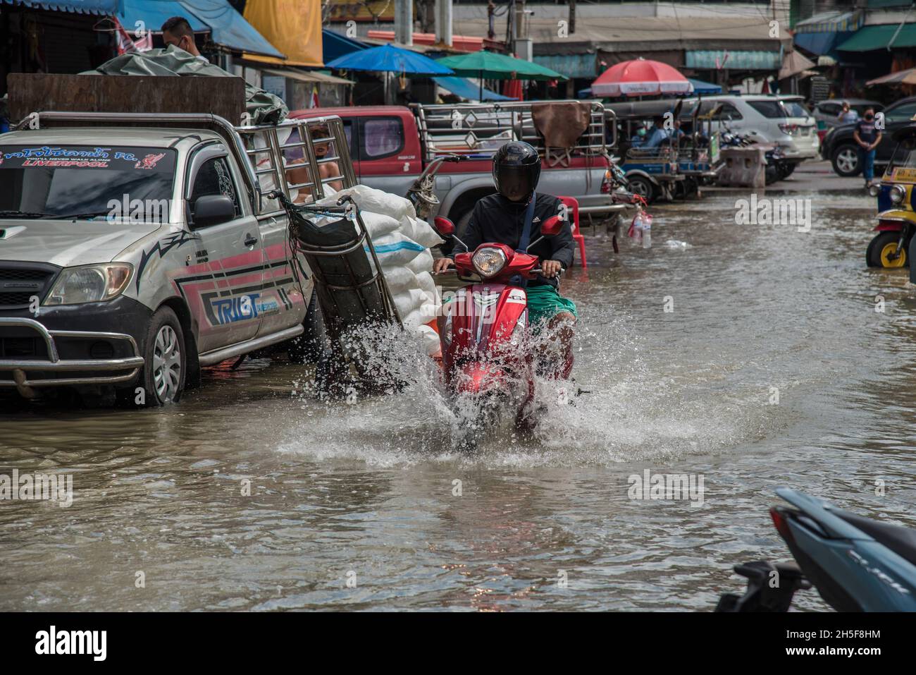 Ein Motorradfahrer fährt während einer Sturzflut auf dem Pak Nam Frischemarkt in Samut Prakan entlang der überfluteten Straße.Blitzfluten ereigneten sich in vielen tief liegenden Gebieten neben dem Chao Phraya Fluss in Bangkok und nahe gelegenen Provinzen wie Samut Prakan in Nonthaburi aufgrund starker Regenfälle. (Foto von Peerapon Boonyakiat / SOPA Images/Sipa USA) Stockfoto