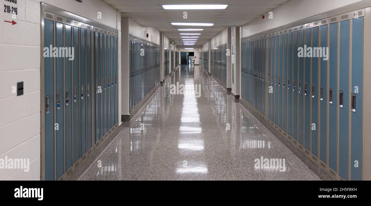Der Flur der amerikanischen High School ist mit Schließfächern und Lichtern auf dem Boden gesäumt Stockfoto