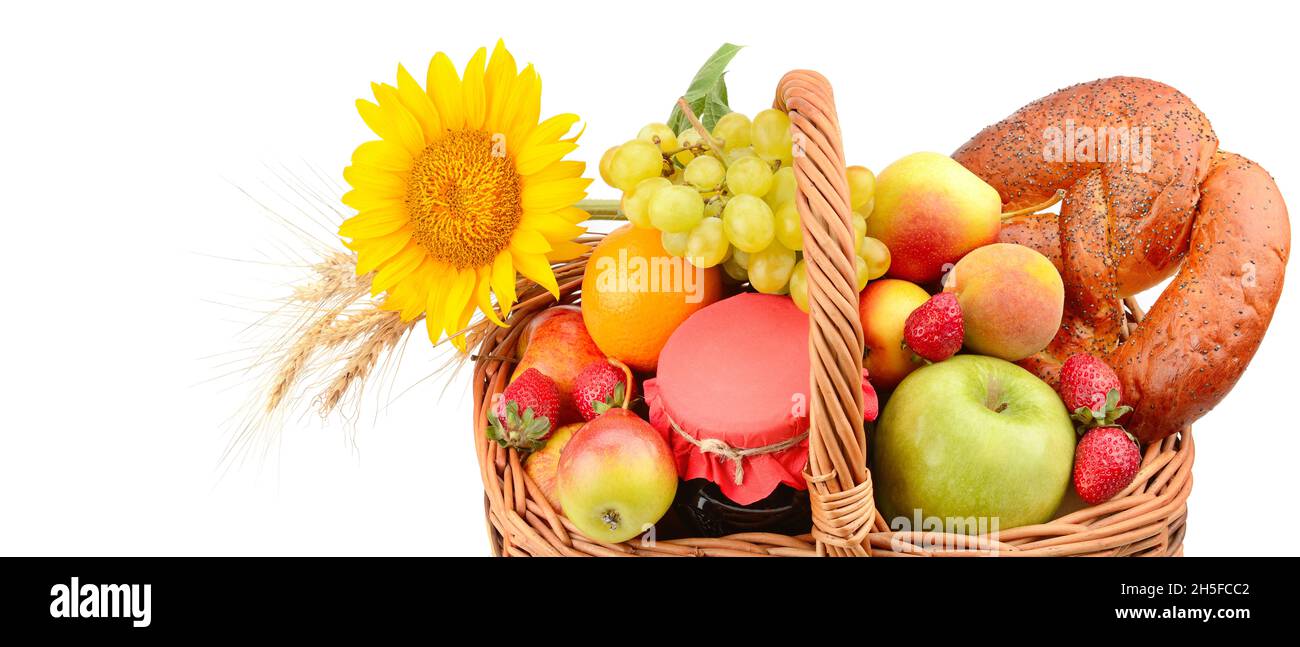 Bio-Lebensmittel isoliert auf weißem Hintergrund. Ein Set aus Obst und Gebäck in einem gewebten Korb. Breites Foto. Freier Speicherplatz für Text. Stockfoto