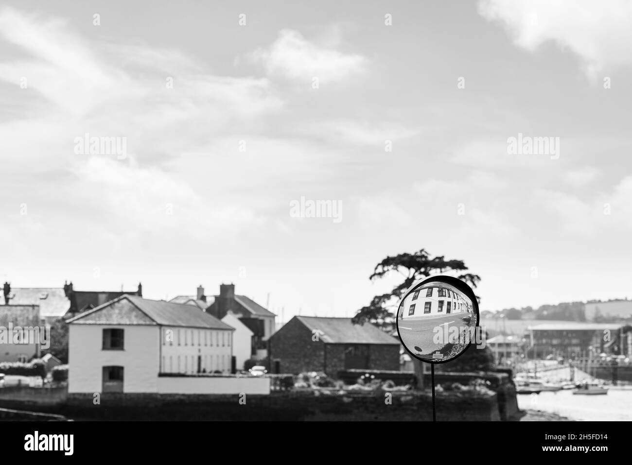 Konvexer Spiegel auf der Straße, um den entgegenkommenden Verkehr zu sehen, der ein Gebäude in Kinsale, County Cork, Irland, widerspiegelt Stockfoto