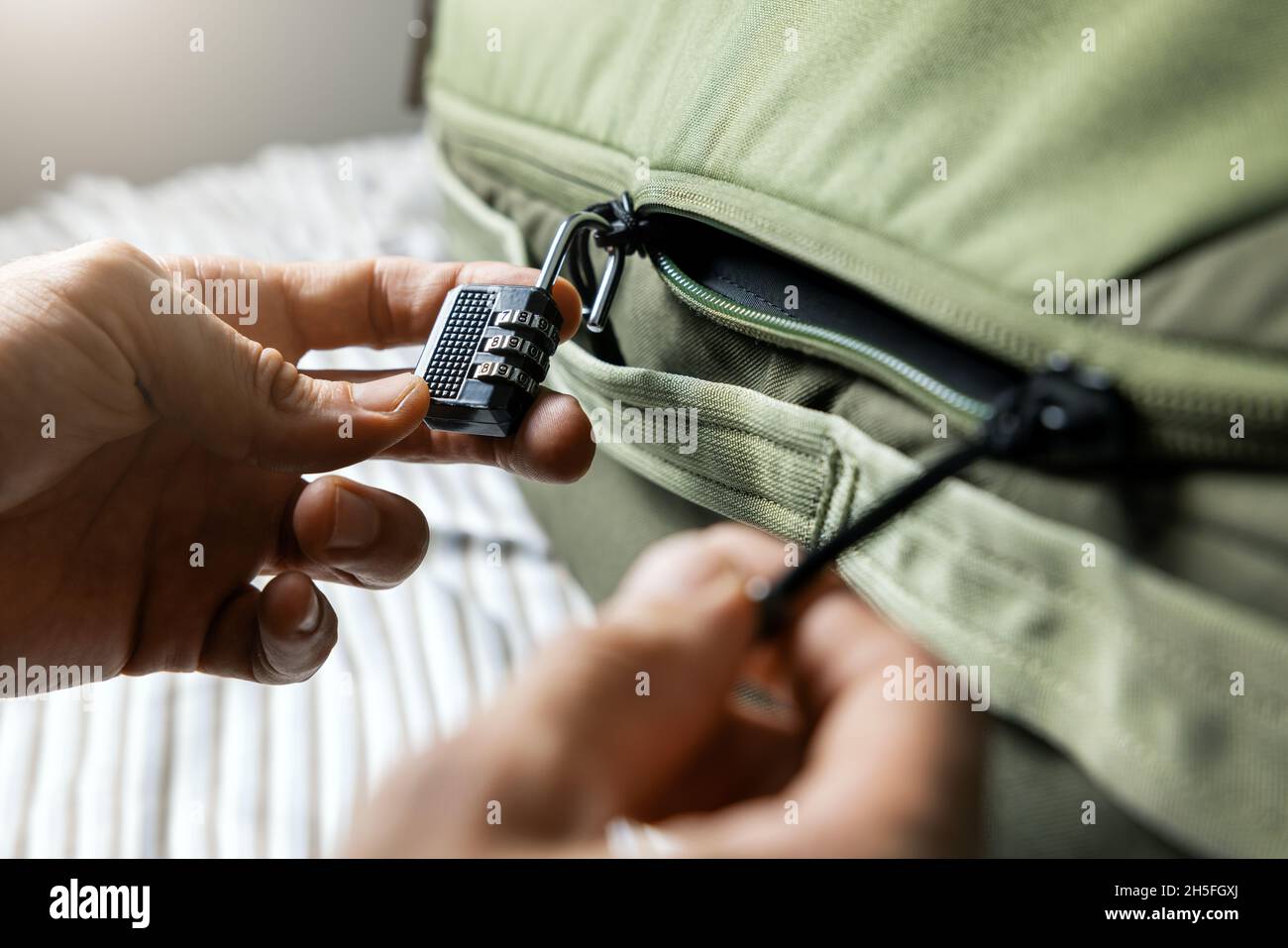 Gepäcksicherheit - Mann schließt den Koffer mit Zahlenschloss Stockfoto