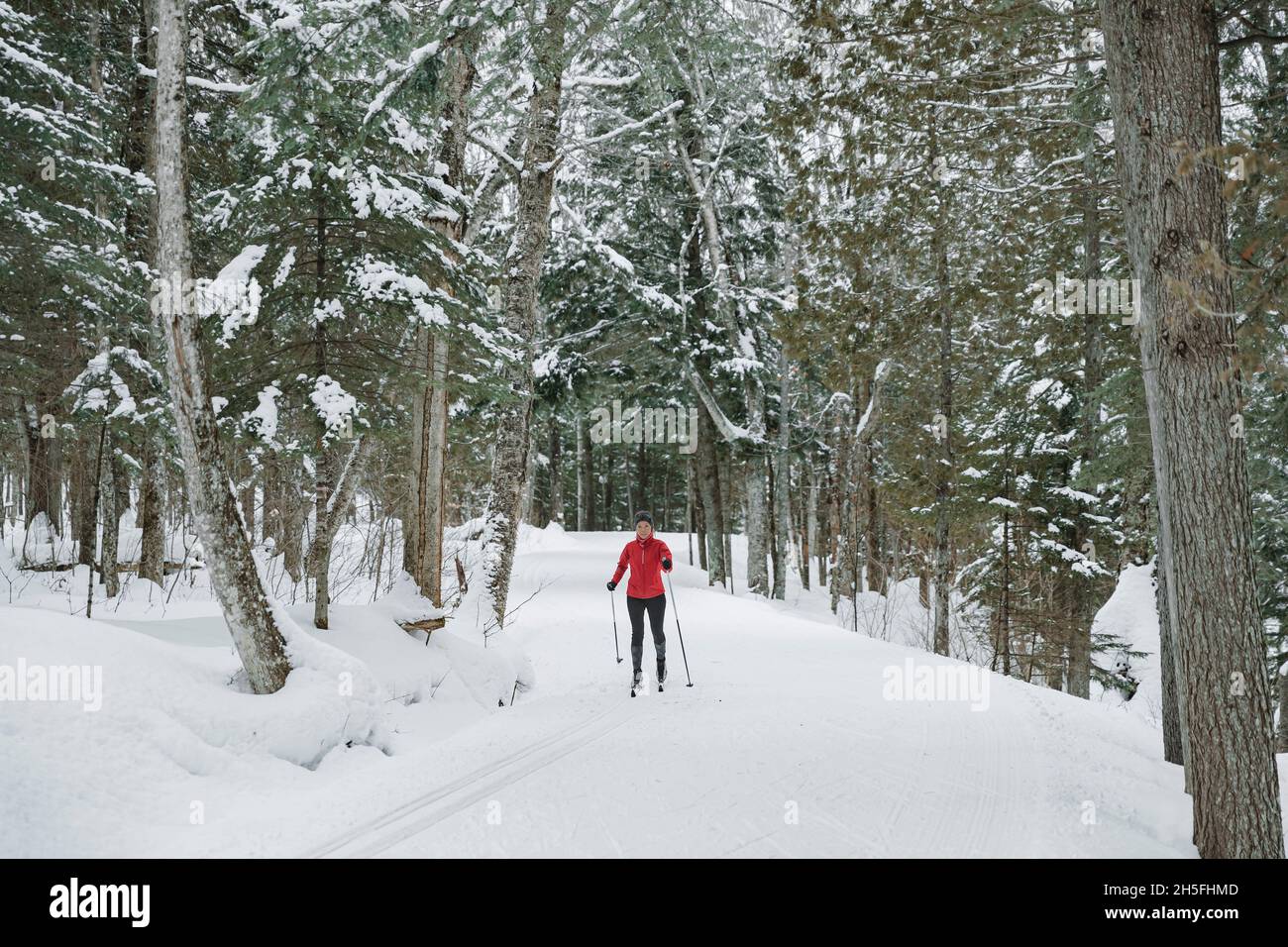 Skilanglauf Klassischer Stil Nordisches Skifahren im Wald. Frau im Winter macht Spaß Wintersport im Schnee auf Langlauf in Stockfoto