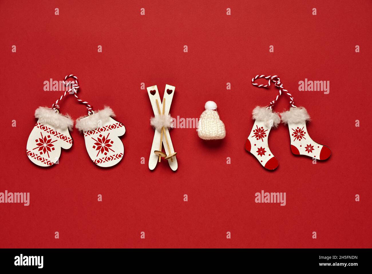 Weihnachtsbanner. Spielzeug-Attribute von Winter und Weihnachten auf rotem Hintergrund. Konzept symbolischer Gegenstände. Draufsicht. Stockfoto