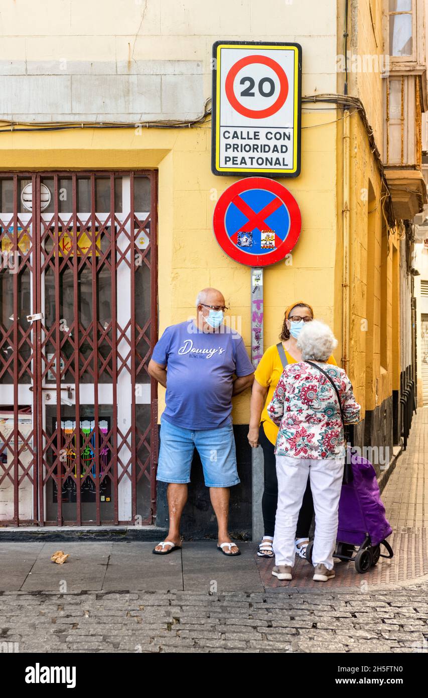 Drei Leute plaudern an der Straßenecke, Cädaz Spanien Stockfoto