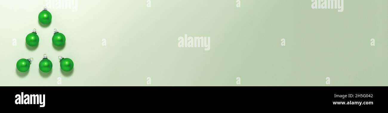 Alternative grüne weihnachtskugeln Baum auf hellem Hintergrund auf der linken Seite. Flache, auflageflaschte Ansicht von oben mit Kopieplatz. Urlaubskonzept Stockfoto