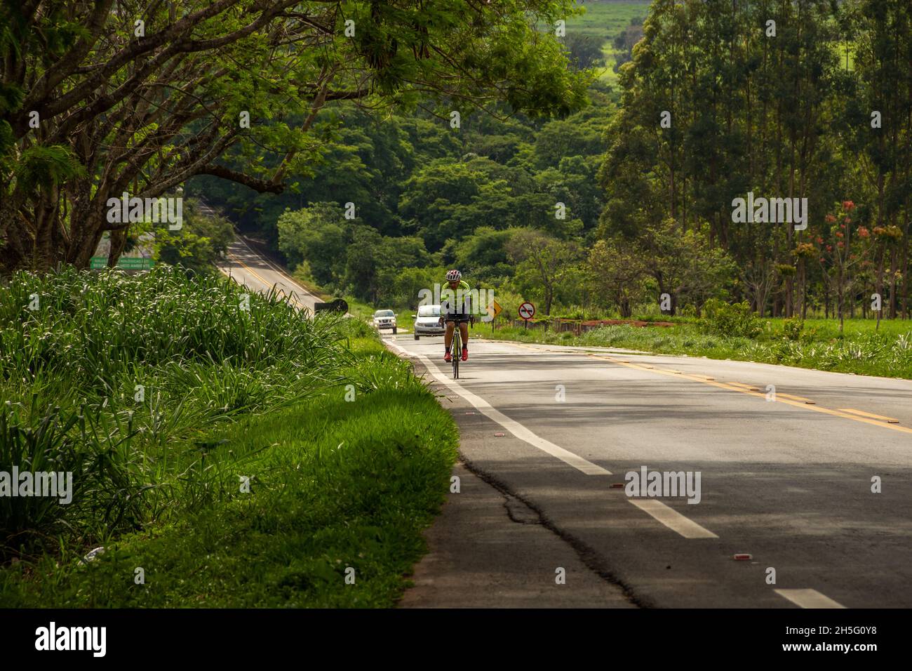 Ein Radfahrer, der auf der Autobahn unterwegs ist. Landschaft eines Abschnitts der Autobahn GO-462 in Goiás. Stockfoto