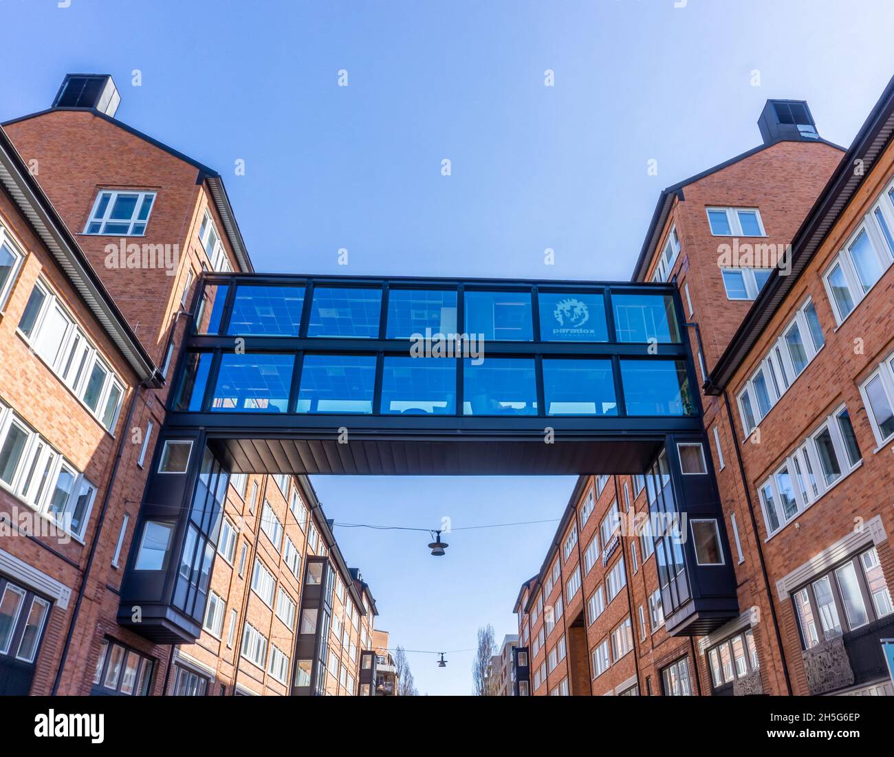 Stockholm, Schweden - 15. April 2021: Hohe Brücke aus Metall und Glas über der Straße zwischen zwei Gebäuden Stockfoto