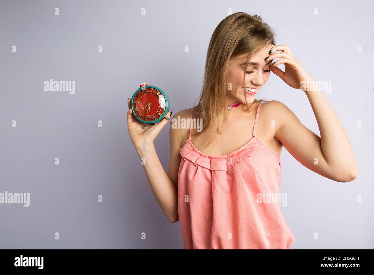 Mädchen mit einer seltenen Uhr in ihren Händen, Wecker, Zeitkonzept Stockfoto