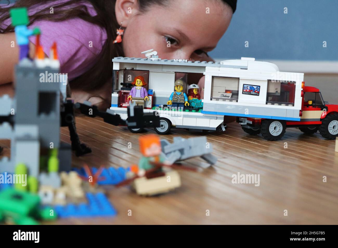 Kind, das mit einem Lego-Reiseanhänger auf dem Campingplatz spielt Stockfoto