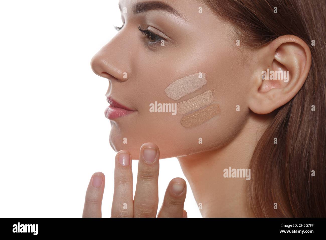 Nahaufnahme Porträt eines jungen Mädchens, das eine Schattierung von Fundament als Basis für Make-up wählt Stockfoto