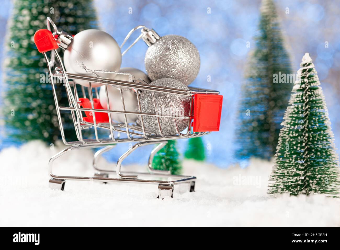 Kauf von Weihnachtsbaumschmuck. Kleine silberne Weihnachtskugeln in einem Supermarktkorb Stockfoto