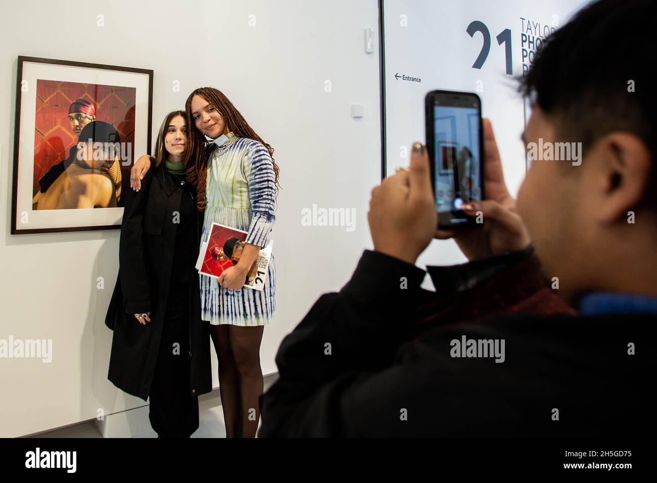 London, England, Großbritannien. November 2021. Cromwell Place, South Kensington, London, Großbritannien. Deleli Ayivi posiert mit ihrem Porträt, das am Londoner Cromwell Place für den renommierten Taylor Wessing Photographic Portrait Prize ausgestellt wird. Die Ausstellung läuft vom 10. November 2021 bis 2. Januar 2022. Es zeigt 54 Porträts von 25 verschiedenen Künstlern. â .der Fotograf David Prichard hat den ersten Preis für seine Tribute to Indigenous Stock Women gewonnen, eine Serie von Porträts von Frauen der First Nations, die den Großteil ihres Arbeitslebens an Viehstationen im Norden von Queensland verbracht haben.der zweite Preis Stockfoto