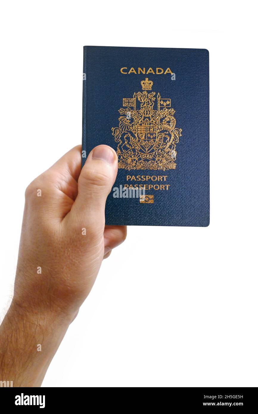 Nahaufnahme auf der Hand eines Mannes mit einem kanadischen Pass vor weißem Hintergrund. Stockfoto