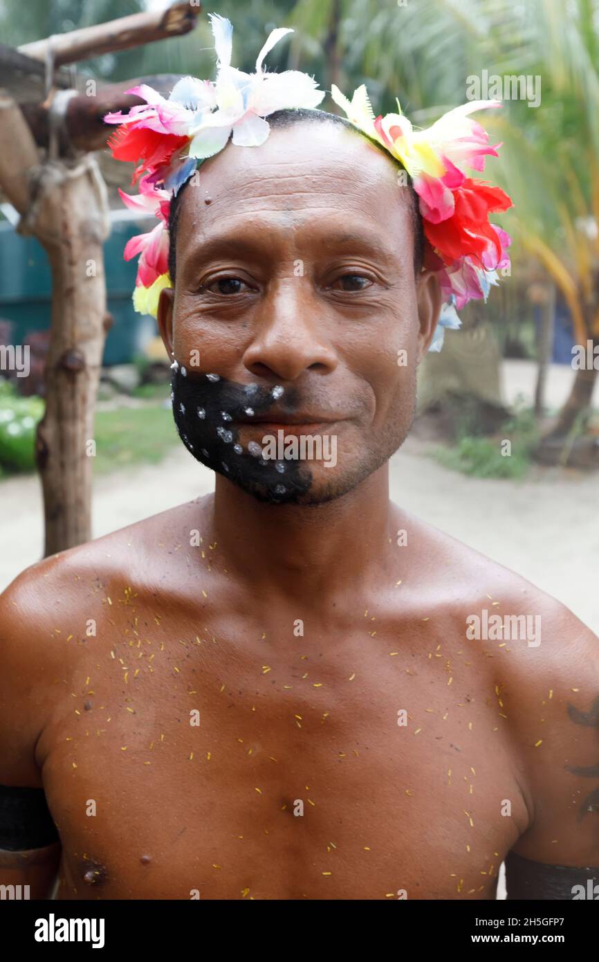 Mann mit Blumen im Haar und schwarzem Make-up auf der Kuiawa-Insel auf den Trobriand-Inseln, Papua-Neuguinea Stockfoto