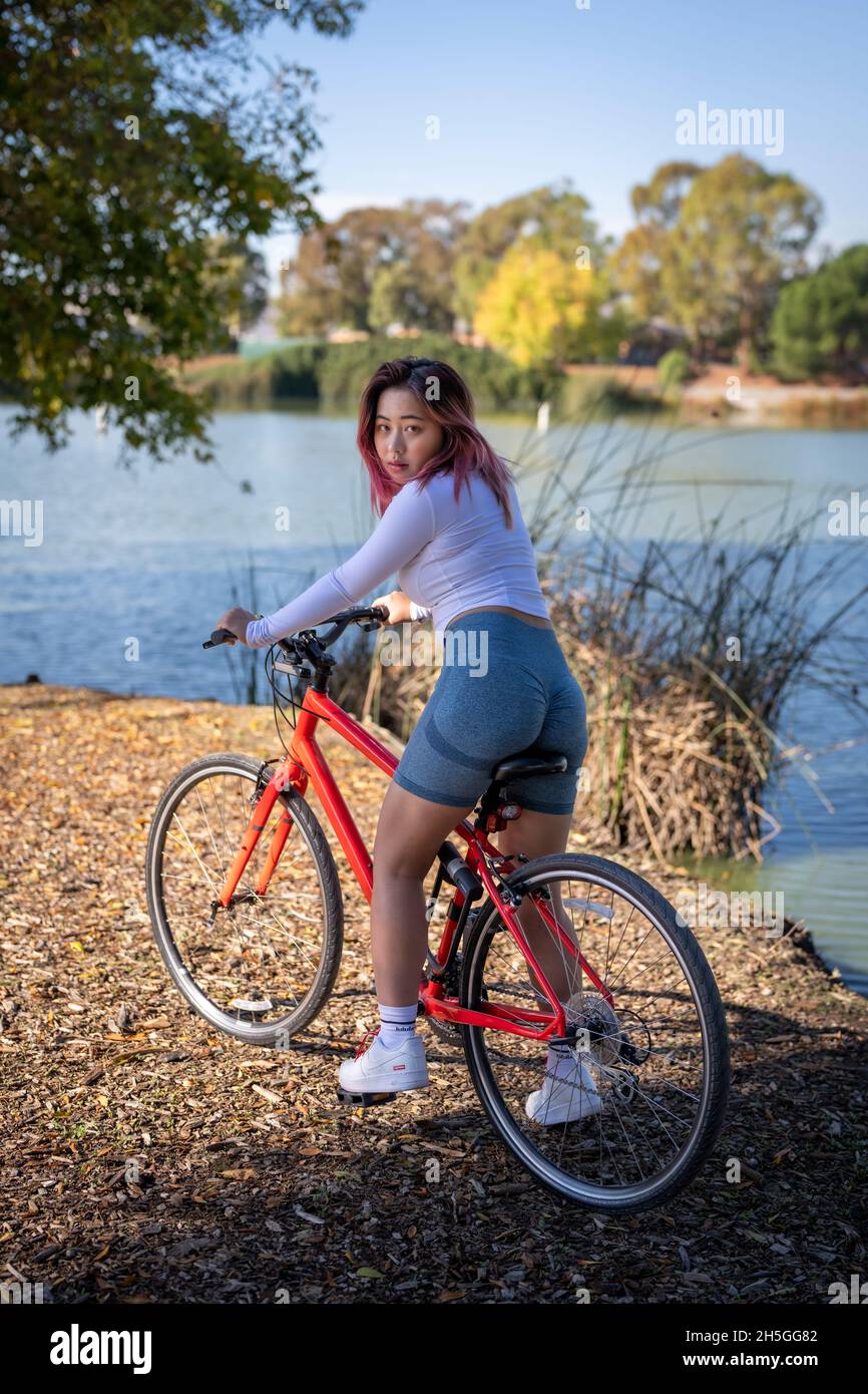 Rückansicht der jungen asiatischen Frau Biker am Seeufer Stockfoto