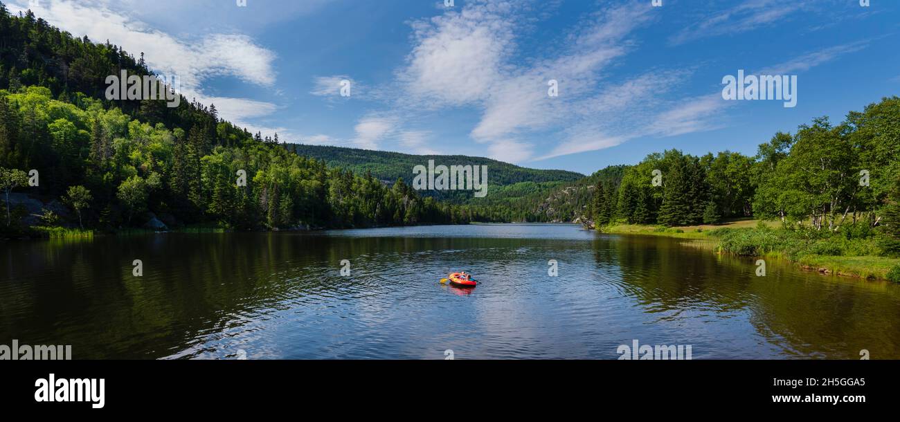 Paddeln mit einem aufblasbaren Boot auf dem ruhigen Fluss in Tadoussac; Tadoussac, Quebec, Kanada Stockfoto Paddeln mit einem aufblasbaren Boot auf dem ruhigen Fluss in Tadoussac; Tadoussac, Quebec, Kanada Stockfoto
