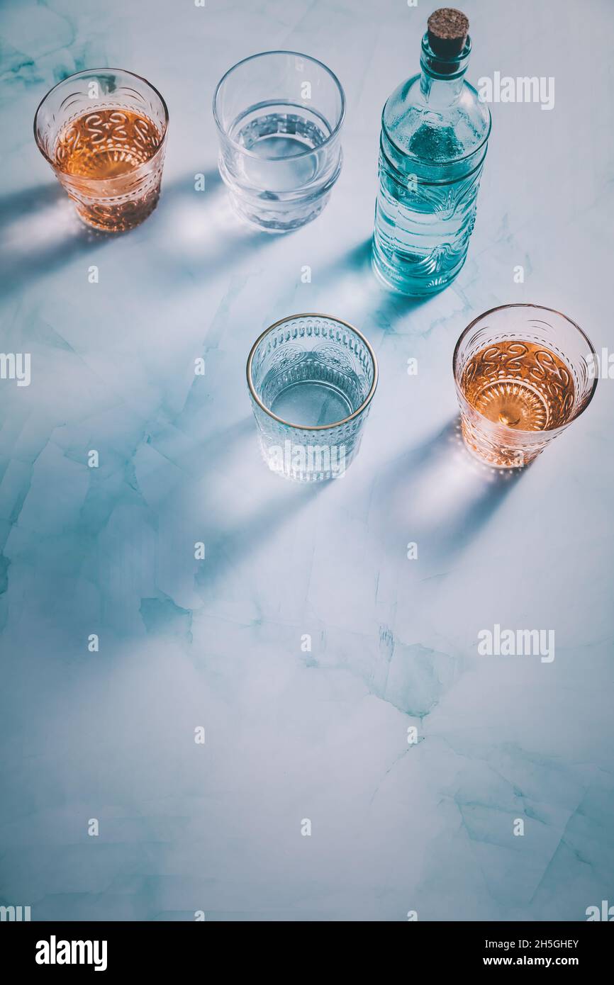Wasser in Vintage-Gläsern mit Flasche Stockfoto
