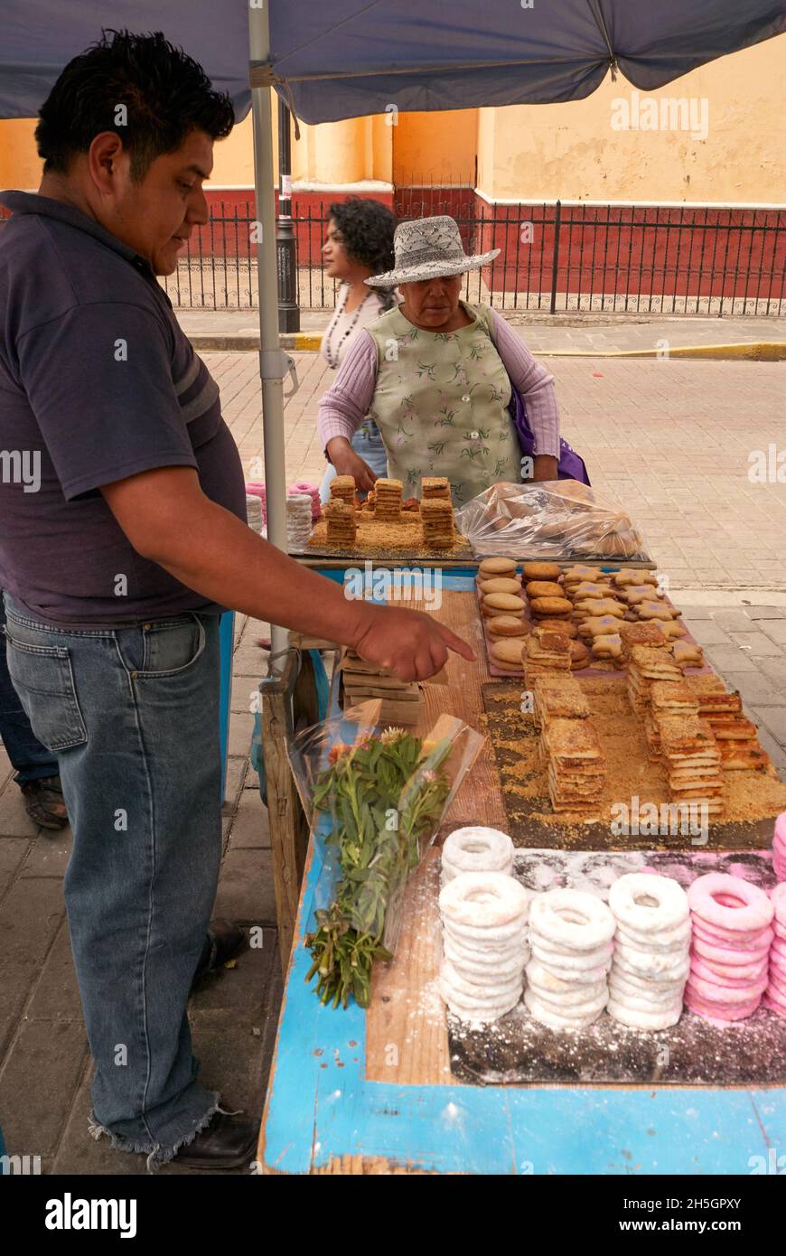 Ältere Frau, die mexikanische Backwaren bei einem Straßenhändler in Cholula, Puebla, Mexiko, kauft Stockfoto