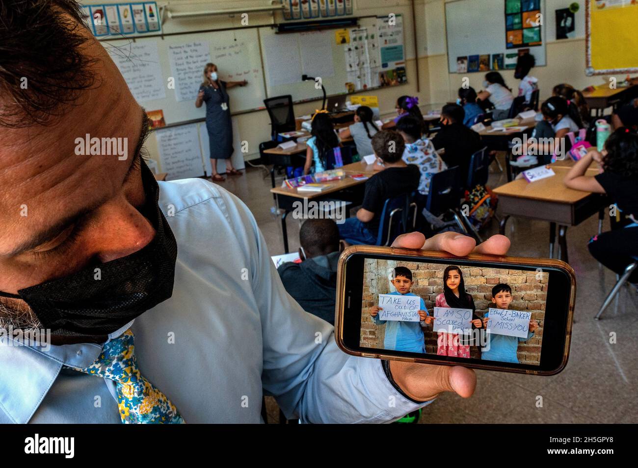 Sacramento, CA, USA. September 2021. Ethel I. Baker Elementary Principal Nate McGill hält ein Foto, das ihm von gestrandeten Schulkindern in Kabul in einem ihrer Klassenräume geschickt wurde und in dem er darum bittet, am Donnerstag, dem 2. September 2021, am ersten Tag wieder zur Schule aus Afghanistan gebracht zu werden. Sie fuhren mehrmals zum Flughafen, in der Hoffnung, nach Sacramento zu fliegen, wo sie seit vier Jahren leben, aber ohne Erfolg. (Bild: © Renée C. Byer/ZUMA Press Wire) Stockfoto