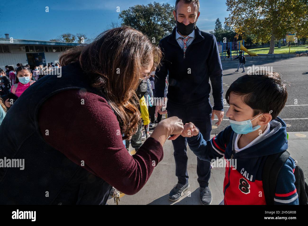 Sacramento, CA, USA. November 2021. Raihan, 6, stößt mit seiner Lehrerin der ersten Klasse, Rosa Marquez, auf die Faust, nachdem ihn die Schulleiterin Nate McGill am Montag, den 8. November 2021, an der Ethel I. Baker Elementary School in Sacramento zu ihr gebracht hatte. Es war sein erster Schultag, nachdem er mit seiner Familie nach der Übernahme des Landes durch die Taliban in Afghanistan gestrandet war. (Bild: © Renée C. Byer/ZUMA Press Wire) Stockfoto