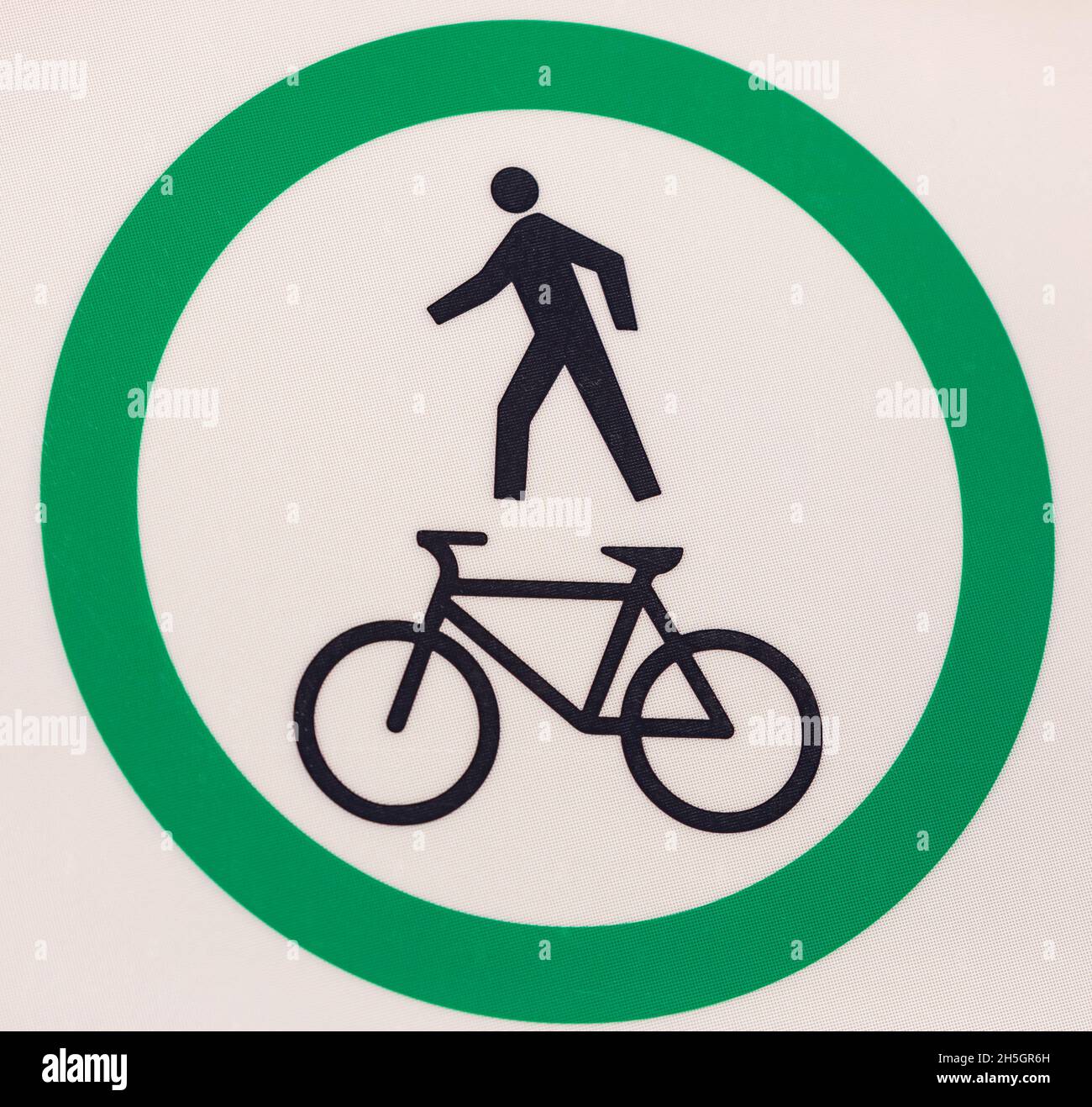 Zeichen eines Fahrrads oder einer Fahrradspur. Fahrrad- und Fußgängerstraßenschild am Pfahl, großer grüner runder, isolierter Fahrrad- und Gehweg Stockfoto