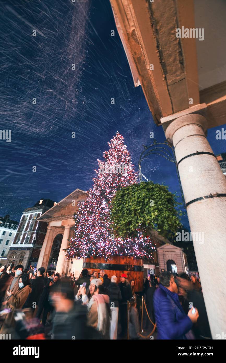 Am 9. November 2021 wurden die Weihnachtslichter von Covent Garden eingeschaltet. Schnee fiel über die Käufer, als sie Fotos vom Baum machten. Der Baum hat 50,000 LED-Leuchten. Stockfoto