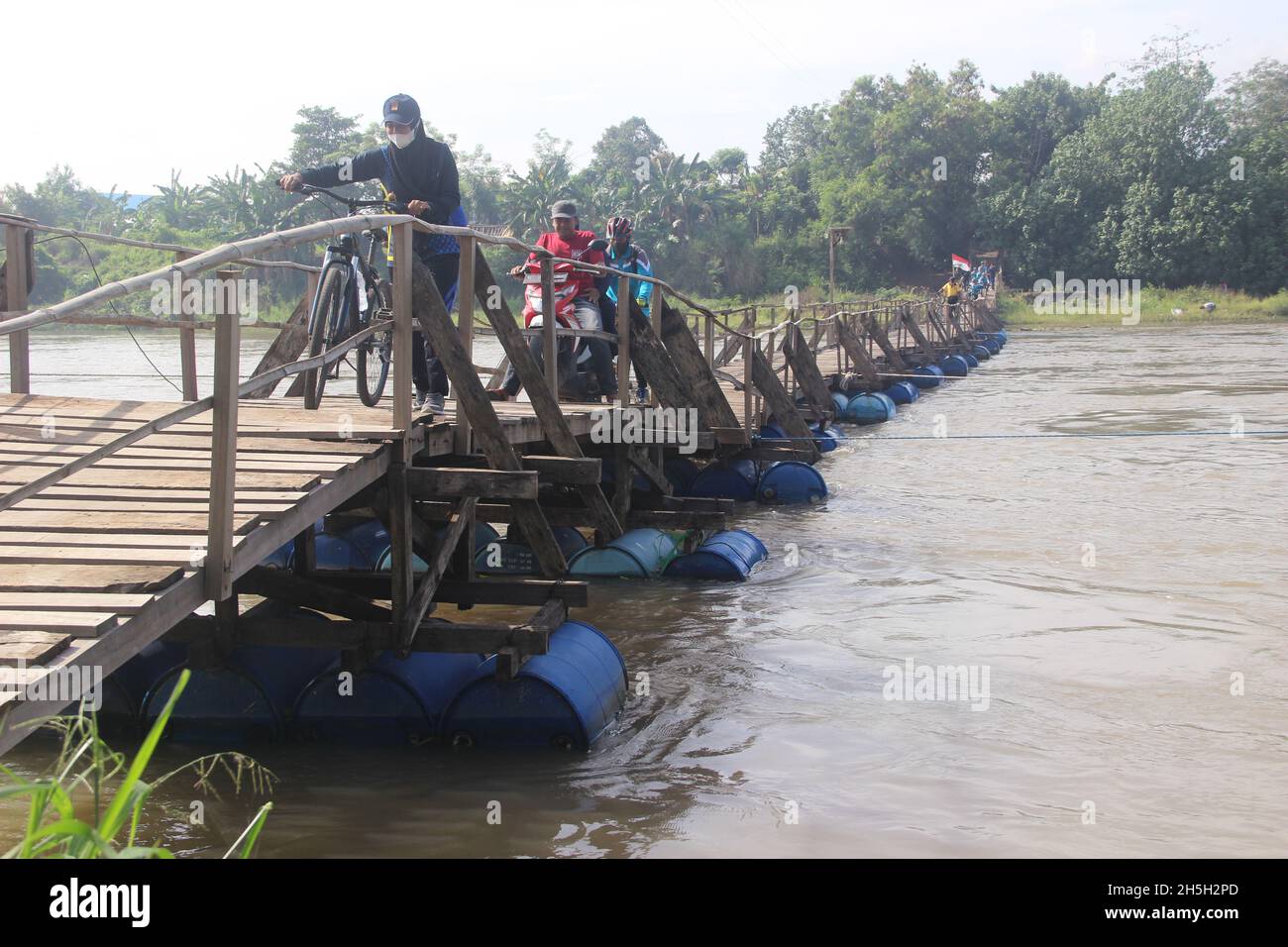 SIDOARJO, INDONESIEN - 06. NOVEMBER 2021: Die schwimmende Brücke (Sutam-Brücke) liegt über dem Brantas-Fluss, Ost-Java. Mount Penanggungan Hintergrund. Grea Stockfoto
