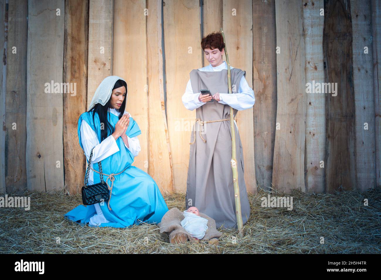 Krippe mit Transgender-Personen, die ein Handy nutzen Stockfoto