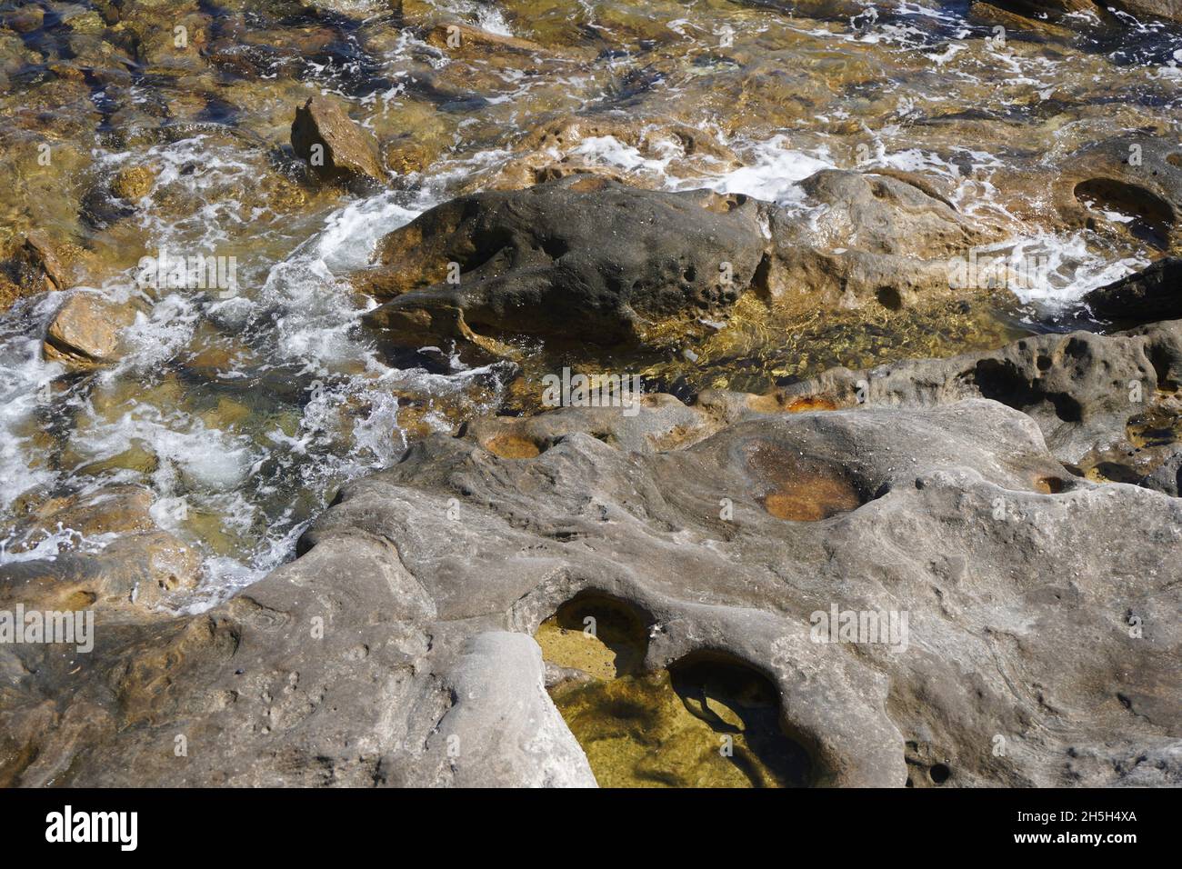 Blick aus dem Hochwinkel auf die vom Wasser umschlingenden Foreshore Rocks Stockfoto