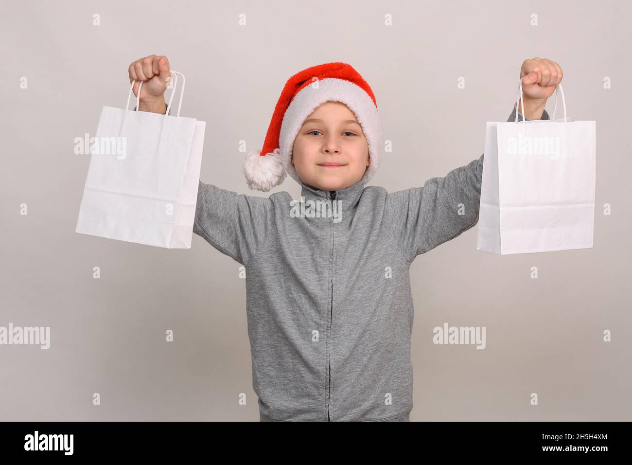 Ein 8-10-jähriger Junge in einem Weihnachtshelfer-Weihnachtshut Stockfoto