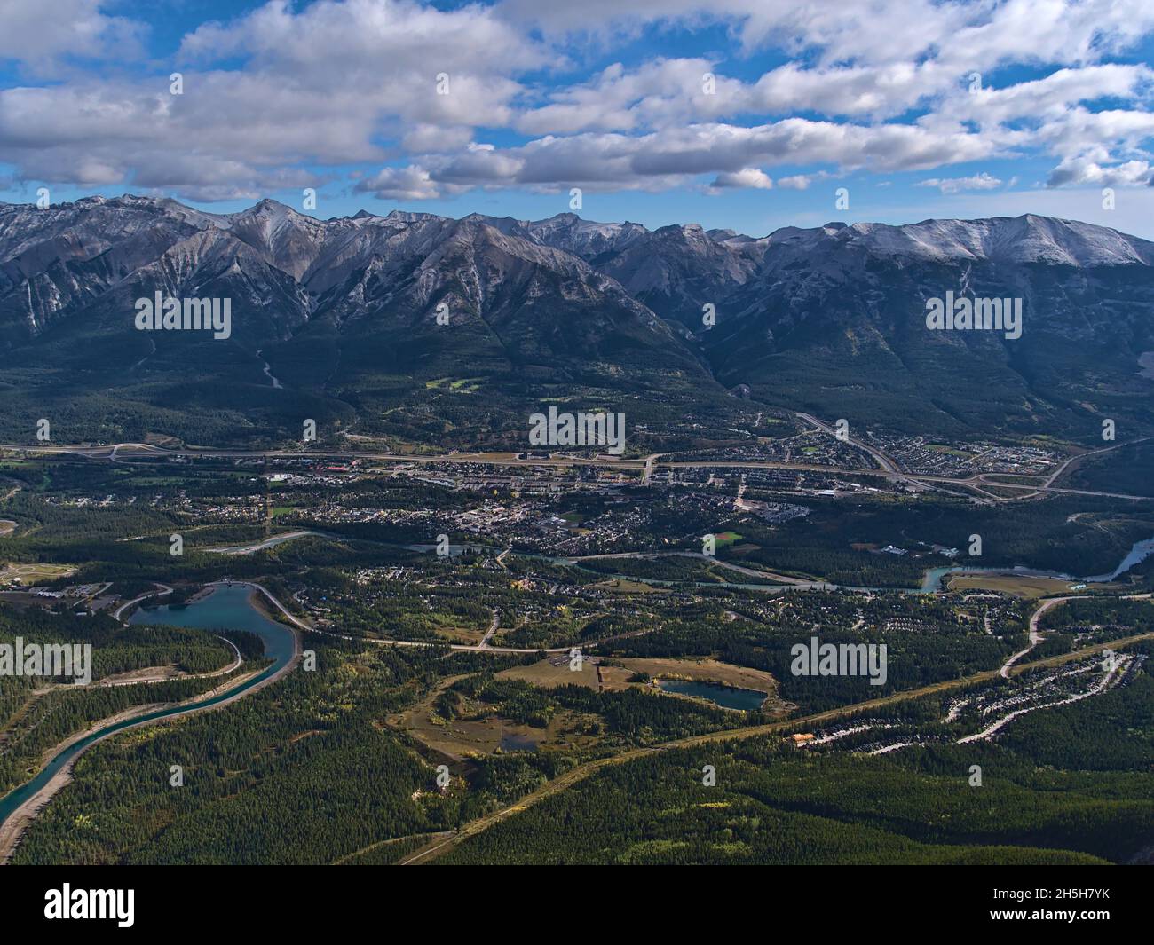 Schöne Luftpanoramasicht auf Bow Valley mit der Stadt Canmore, Alberta, Kanada in den Rocky Mountains mit Rundle Forebay Reservoir und Wäldern. Stockfoto