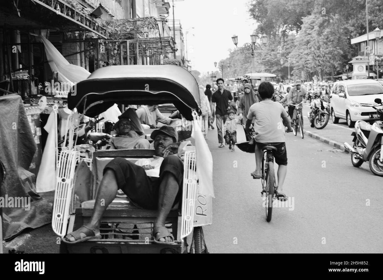Rikscha-Fahrer ruht auf seiner Rikscha, Malioboro Street, Yogyakarta, Indonesien. Stockfoto