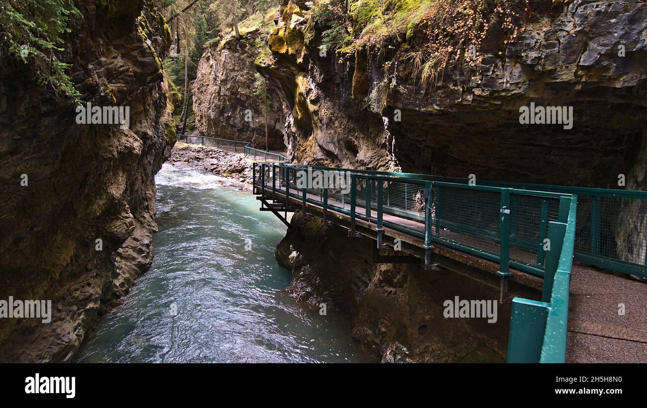 Schwindende Perspektive eines abenteuerlichen Wanderweges, der durch eine enge felsige Schlucht im Johnston Canyon, Banff National Park, Alberta, Kanada führt. Stockfoto